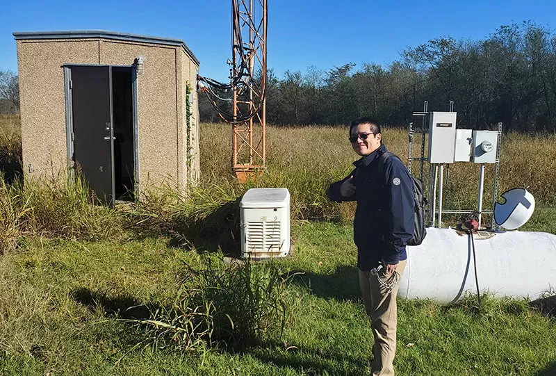 Propane tank outside a county radio facility with DPS engineer surveying the site