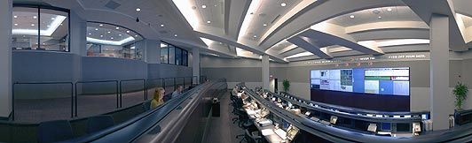 Image of a Network Command Center showing rows of desks with computers and workers monitoring their remote network. Workers are ready to dispatch a technician when critical alarms are triggered.